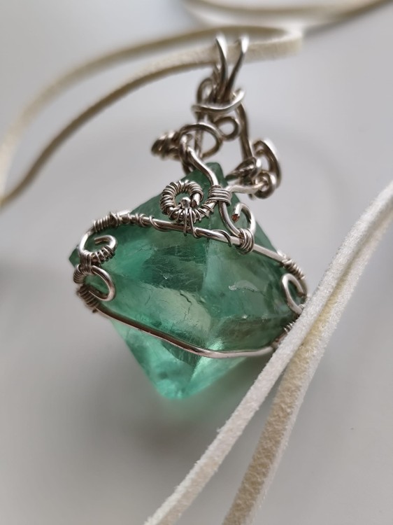 Wisiorek z naturalnego fluorytu opleciony posrebrzanym drutem