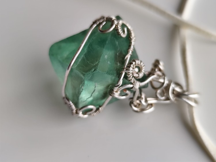 Wisiorek z naturalnego fluorytu opleciony posrebrzanym drutem