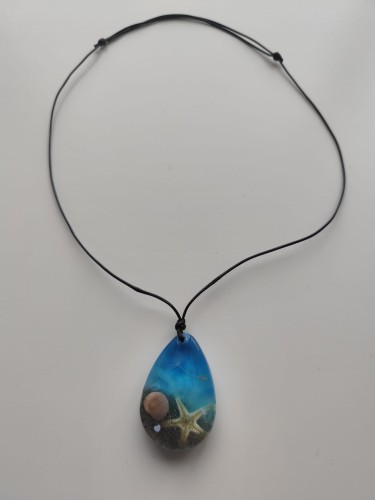 Zawieszka z muszlami w błękitnej żywicy na czarnym sznurku jubilerskim