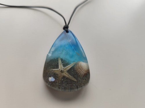 Zawieszka z muszlami w błękitnej żywicy - widok zbliżony