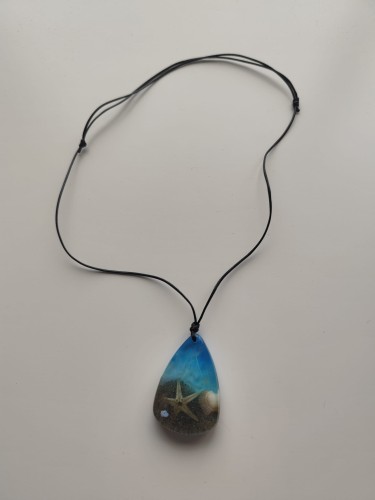 Zawieszka z muszlami w błękitnej żywicy na czarnym sznurku jubilerskim