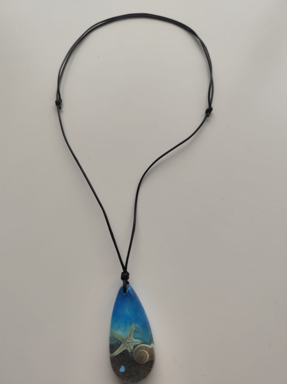 Zawieszka z muszlami w błękitnej żywicy na czarnym sznurku jubilerskim