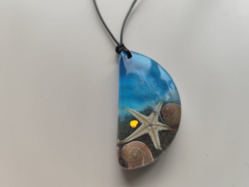 Zawieszka z muszlami w błękitnej żywicy - widok zbliżony