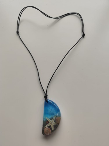 Zawieszka z muszlami w błękitnej żywicy na czarnym sznurku jubilerskim