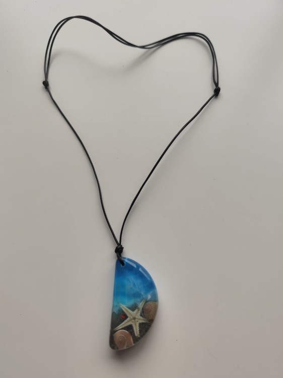 Zawieszka z muszlami w błękitnej żywicy na czarnym sznurku jubilerskim