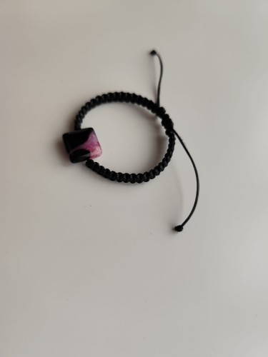 Bransoletka z kamieniem agatu w odcieniach czerni i różu na czarnym sznurku - widok pod kątem