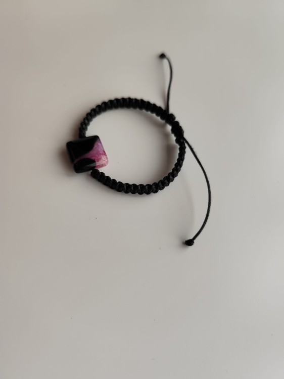Bransoletka z kamieniem agatu w odcieniach czerni i różu na czarnym sznurku - widok pod kątem