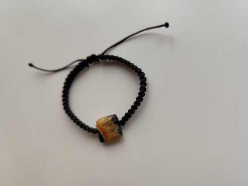 Bransoletka z kamieniem agatu w odcieniach czerni i jasnej pomarańczy na czarnym sznurku - widok pod kątem