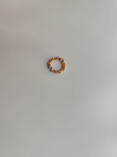 Pierścionek z kamieni w odcieniach bieli i pomarańczy oraz złotych koralików TOHO - widok pod kątem