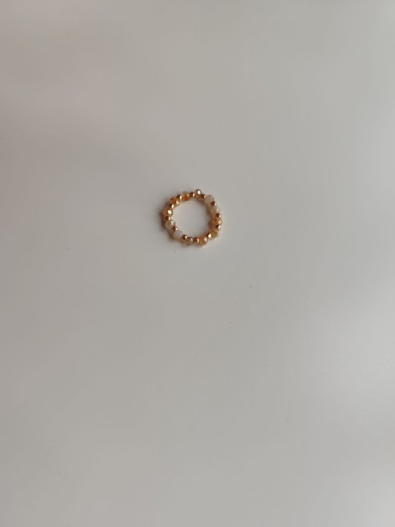 Pierścionek z kamieni w odcieniach bieli i pomarańczy oraz złotych koralików TOHO - widok pod kątem