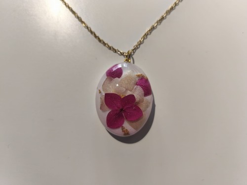 Zawieszka z białej żywicy z hortensją i złotą folią - widok zbliżony