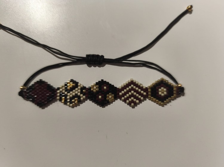 Bransoletka z koralików MIYUKI w kolorach czerni, bieli, brązu i złota na czarnym sznurku - widok z góry