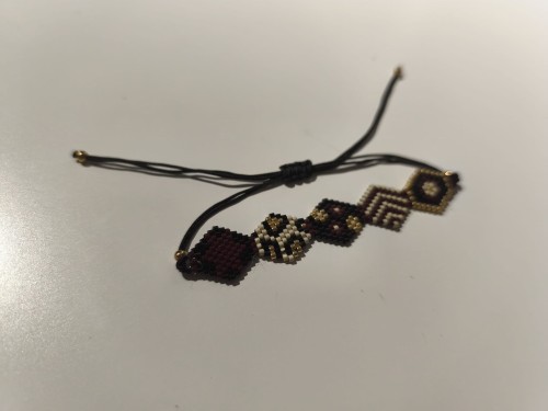 Bransoletka z koralików MIYUKI w kolorach czerni, bieli, brązu i złota na czarnym sznurku - widok pod kątem