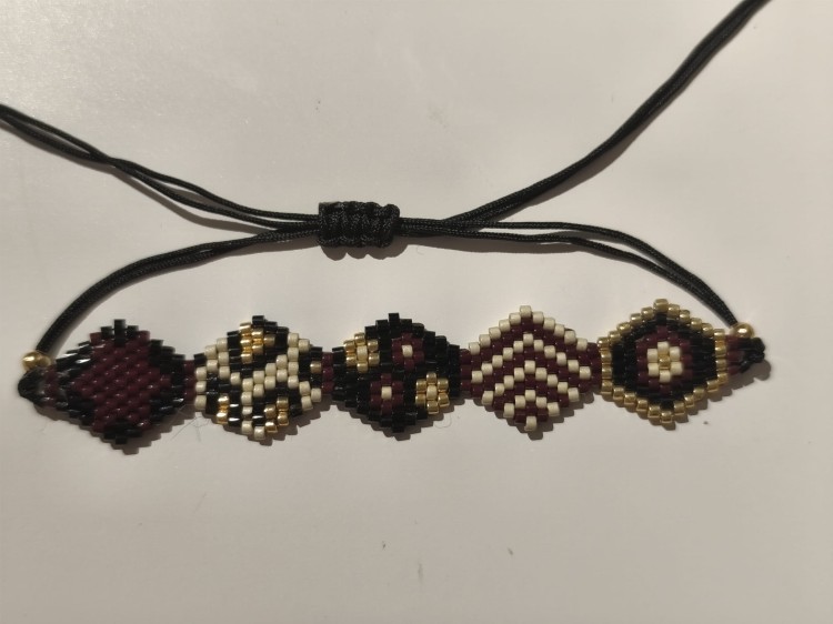 Bransoletka z koralików MIYUKI w kolorach czerni, bieli, brązu i złota na czarnym sznurku - widok zbliżony