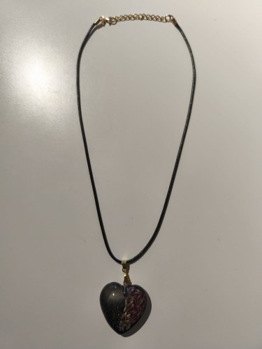 Zawieszka w kształcie serca z nasionami wrzosu i brokatem zatopionymi w ciemnej żywicy