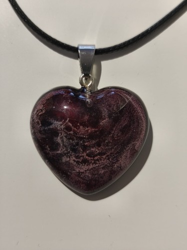 Zawieszka w kształcie serca z brokatowego fioletowego piasku zatopionego w żywicy - zbliżenie
