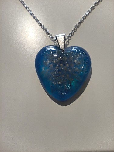 Zawieszka z niebieskiej żywicy z nasionami dmuchawca i kruszonym szkłem - widok zbliżony